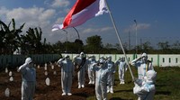 Sejumlah relawan pemakaman jenazah protokol COVID-19 dengan mengenakan Alat Pelindung Diri (APD) melakukan upacara bendera dalam rangka peringatan Hari Ulang Tahun ke-76 Proklamasi Kemerdekaan RI di Pemakaman Pagu Indah Kota Madiun, Jawa Timur, Minggu (15/8/2021). Para relawan pemakaman jenazah tersebut terdiri dari unsur Palang Merah Indonesia (PMI), Badan Penanggulangan Bencana Daerah (BPBD) dan Puskesmas. ANTARA FOTO/Siswowidodo  