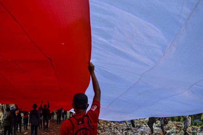 Pegiat Lingkungan Bentangkan Bendera Merah Putih di TPA Ciangir Sejumlah pegiat lingkungan yang tergabung dalam komunitas Republik Aer membentangkan bendera merah putih di Tempat Pembuangan Akhir Sampah (TPAS) Cianggir, Kota Tasikmalaya, Jawa Barat, Minggu (15/8/2021). Pembentangan bendera merah putih raksasa di TPAS tersebut dilakukan dalam rangkaian acara menyambut peringatan HUT Kemerdekaan ke-76 RI, sekaligus mengampanyekan kepedulian terhadap lingkungan dan menjaga ekosistem di masa pandemi COVID-19 serta memupuk rasa nasionalisme. ANTARA FOTO/Adeng Bustomi/wsj.