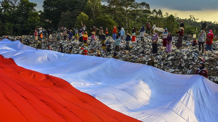 Pegiat Lingkungan Bentangkan Bendera Merah Putih di TPA Ciangir Sejumlah pegiat lingkungan yang tergabung dalam komunitas Republik Aer membentangkan bendera merah putih di Tempat Pembuangan Akhir Sampah (TPAS) Cianggir, Kota Tasikmalaya, Jawa Barat, Minggu (15/8/2021). Pembentangan bendera merah putih raksasa di TPAS tersebut dilakukan dalam rangkaian acara menyambut peringatan HUT Kemerdekaan ke-76 RI, sekaligus mengampanyekan kepedulian terhadap lingkungan dan menjaga ekosistem di masa pandemi COVID-19 serta memupuk rasa nasionalisme. ANTARA FOTO/Adeng Bustomi/wsj.