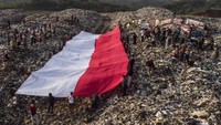 Foto udara pembentangan bendera merah putih oleh sejumlah pegiat lingkungan yang tergabung dalam komunitas Republik Aer di Tempat Pembuangan Akhir Sampah (TPAS) Cianggir, Kota Tasikmalaya, Jawa Barat, Minggu (15/8/2021).