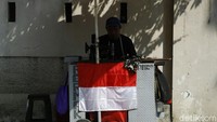 Salah satu penjahit memasang bendera merah putih di lapaknya kawasan Manggarai, Jakarta, Senin (16/8/2021).