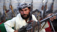 Salah seorang pejuang Taliban meletakkan senjata usai menyerah pada Pemerintah Provinsi Herat pada Oktober 2009. Siapa sangka, kini kelompok tersebut malah menguasasi Afghanistan. Majid/Getty Images.