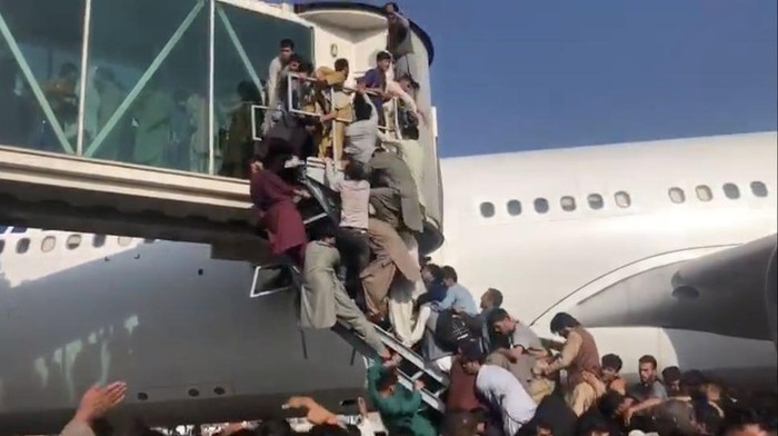 Taliban Berkuasa, Bandara Afghanistan Chaos Ribuan warga Afghanistan berebut masuk ke dalam pesawat di bandara Kabul, Afghanistan.