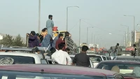 Keluarga Afghanistan membawa barang-barang dalam perjalanan untuk melarikan diri dari kota Kabul, Afghanistan. Foto: Anadolu Agency Via Getty Images