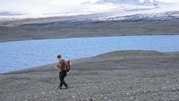 Pengunjung berjalan di antara bongkahan es yang berasal dari gletser Breidamerkurjokull di Islandia.  