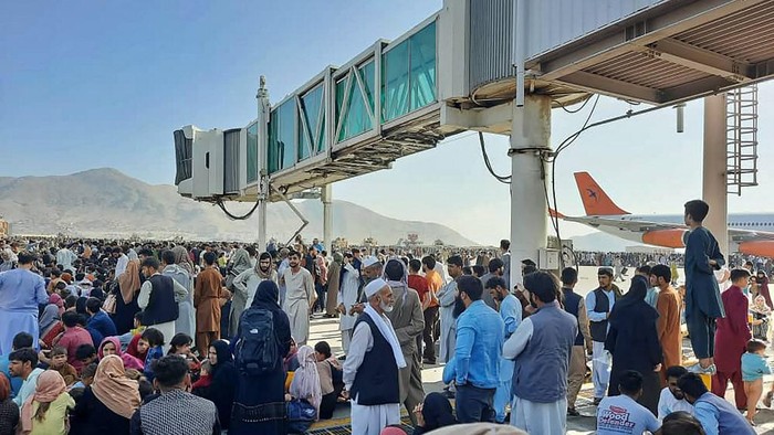 Afghans crowd at the tarmac of the Kabul airport on August 16, 2021, to flee the country as the Taliban were in control of Afghanistan after President Ashraf Ghani fled the country and conceded the insurgents had won the 20-year war. (Photo by - / AFP)