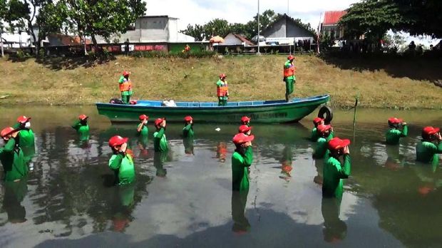 Puluhan personel Satuan Tugas (Satgas) Kali Ngrowo Tulungagung gelar upacara bendera peringatan HUT RI. Upacara berlangsung di tengah sungai.