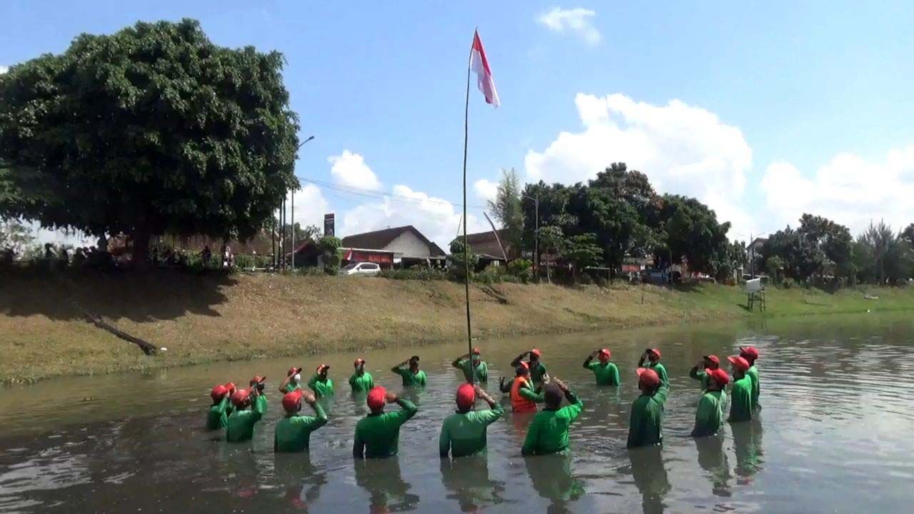 Puluhan personel Satuan Tugas (Satgas) Kali Ngrowo Tulungagung gelar upacara bendera peringatan HUT RI. Upacara berlangsung di tengah sungai.