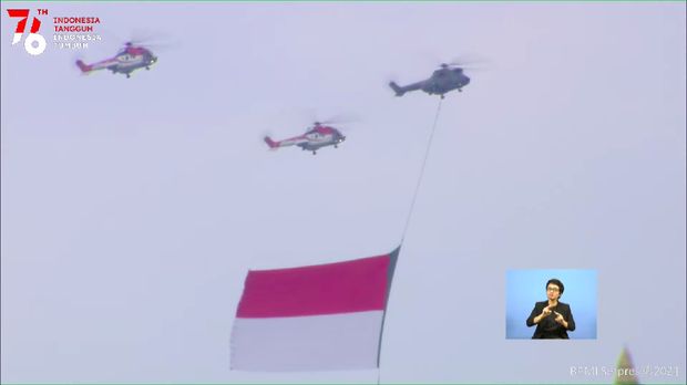 Helikopter TNI AU Membawa Bendera Merah Putih Raksasa