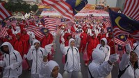 Penari menunjukan bendera nasional Malaysia saat perayaan kemerdekaan di Kuala Lumpur (31/8/2013). Usai merdeka, Malaysia memilih bentuk negara monarki parlementer dengan sistem pemerintahan federal.  (Photo by Rahman Roslan/Getty Images)