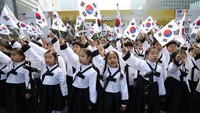 Para pelajar menyanyikan lagu kebangsaan dan mengibarkan bendera nasional saat merayakan hari kemerdekaan di Seoul, Korea Selatan (15/8/2019). Korea Selatan merayakan kemerdekaan dari penjajahan Jepang 1945.