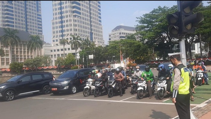 Momen pengendara di kawasan Patung Kuda, Jakpus, menghentikan lajunya saat waktu menunjukkan pukul 10.17 WIB, Selasa (17/8/2021).