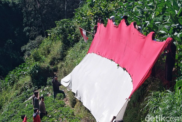 Warga Dukuh Selo Tengah Desa Selo Kecamatan Selo Boyolali Jawa Tengah menggelar pengibaran bendera raksasa di lereng Gunung Merapi. Begini potretnya.