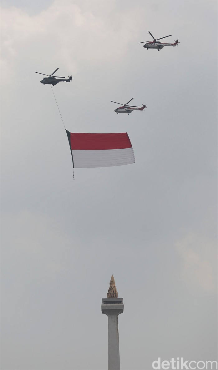 Bendera Merah Putih berukuran raksasa menghiasi langit Jakarta. Bendera itu dibawa oleh pesawat tempur dan helikopter di tengah perayaan HUT ke-76 RI.