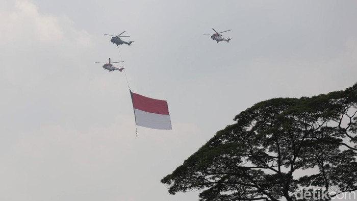 Bendera Merah Putih berukuran raksasa menghiasi langit Jakarta. Bendera itu dibawa oleh pesawat tempur dan helikopter di tengah perayaan HUT ke-76 RI.