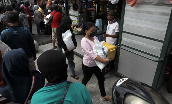 Warga Antri Tanpa Jaga Jarak Demi 10 Kg Beras di Yogyakarta Pembagian BST berupa beras 10 kilogram dilakukan di Kantor Pos Besar, Yogyakarta, Selasa (17/8/2021). Warga tampak mengantre dengan mengabaikan protokol kesehatan.
