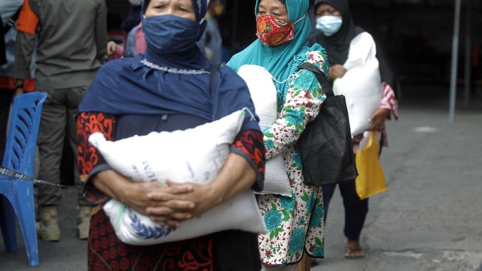 Pembagian BST berupa beras 10 kilogram dilakukan di Kantor Pos Besar, Yogyakarta, Selasa (17/8/2021). Warga tampak mengantre dengan mengabaikan protokol kesehatan.