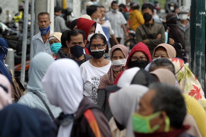Pembagian BST berupa beras 10 kilogram dilakukan di Kantor Pos Besar, Yogyakarta, Selasa (17/8/2021). Warga tampak mengantre dengan mengabaikan protokol kesehatan.