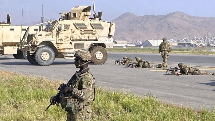 U.S. soldiers stand guard along a perimeter at the international airport in Kabul, Afghanistan, Monday, Aug. 16, 2021. On Monday, the U.S. military and officials focus was on Kabul’s airport, where thousands of Afghans trapped by the sudden Taliban takeover rushed the tarmac and clung to U.S. military planes deployed to fly out staffers of the U.S. Embassy, which shut down Sunday, and others. (AP Photo/Shekib Rahmani)