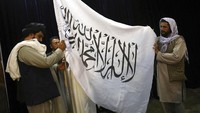 Bendera Taliban dikibarkan saat konferensi pers perdana setelah menguasai Afghanistan. Dalam konferensi pers ini, Taliban berjanji untuk tidak melakukan balas dendam terhadap lawan-lawan mereka di Afghanistan. AP Photo/Rahmat Gul.