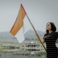 Wulan Guritno tak lupa merayakan HUT ke-76 RI di sela-sela liburannya di Garut. Wulan berpose di tepi danau sambil memegang bendera merah putih. Foto: Instagram
