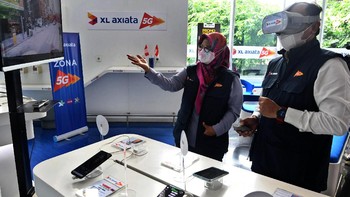 Presiden Direktur & CEO XL Axiata Dian Siswarini (kiri) bersama Direktur & Chief Technology Officer I Gede Darmayusa (kanan) mencoba demo layanan 5G yang tersedia di XL Center, XL Axiata Tower, Jakarta, Rabu (18/8/2021). 