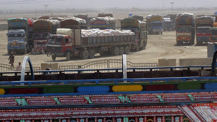 Delivery trucks inbound for Afghanistan wait to move towards the Afghan side at a border crossing point, in Chaman, Pakistan, Wednesday, Aug. 18, 2021. Chaman is a key border crossing between Pakistan and Afghanistan, normally thousands of Afghans and Pakistanis cross daily and a steady stream of trucks passes through, taking goods to Afghanistan. (AP Photo/Jafar Khan)