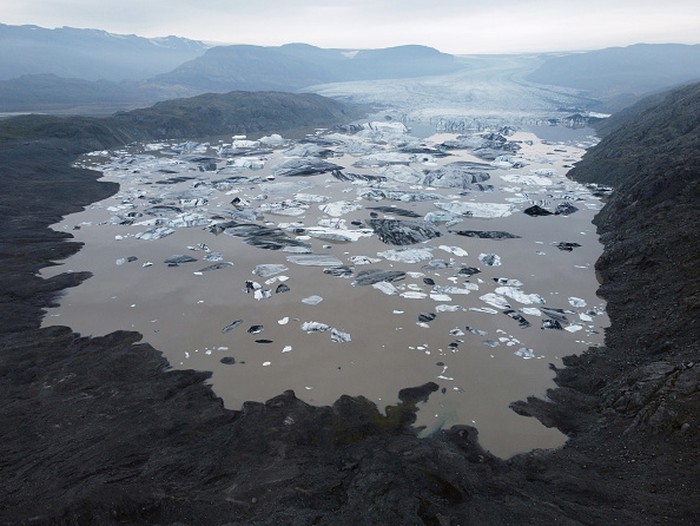 HOFN, HORNAFJORDUR, ICELAND - AUGUST 17: In this aerial view Hoffellsjokull glacier lies behind moraines and an iceberg-filled lagoon the glacier once covered on August 17, 2021 near Hofn, Iceland. Iceland is feeling a strong impact from global warming. Since the 1990s 90% of Icelands glaciers have been retreating and projections for the future show a continued and strong reduction in size of its five ice caps. Flaajokull is one of dozens of glacier tongues that descend from Vatnajokull, Icelands biggest ice cap.  (Photo by Sean Gallup/Getty Images)