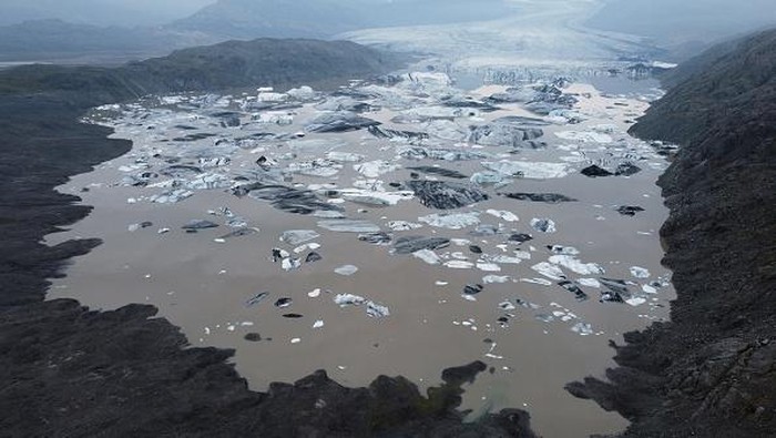 Pemanasan Global Makin Mengkhawatirkan HOFN, HORNAFJORDUR, ICELAND - AUGUST 17: In this aerial view Hoffellsjokull glacier lies behind moraines and an iceberg-filled lagoon the glacier once covered on August 17, 2021 near Hofn, Iceland. Iceland is feeling a strong impact from global warming. Since the 1990s 90% of Iceland's glaciers have been retreating and projections for the future show a continued and strong reduction in size of its five ice caps. Flaajokull is one of dozens of glacier tongues that descend from Vatnajokull, Iceland's biggest ice cap. (Photo by Sean Gallup/Getty Images)