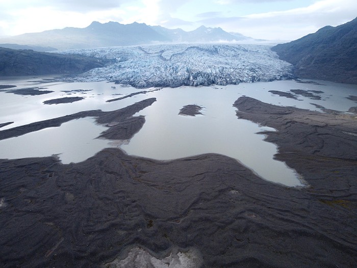 HOFN, HORNAFJORDUR, ICELAND - AUGUST 17: In this aerial view Hoffellsjokull glacier lies behind moraines and an iceberg-filled lagoon the glacier once covered on August 17, 2021 near Hofn, Iceland. Iceland is feeling a strong impact from global warming. Since the 1990s 90% of Icelands glaciers have been retreating and projections for the future show a continued and strong reduction in size of its five ice caps. Flaajokull is one of dozens of glacier tongues that descend from Vatnajokull, Icelands biggest ice cap.  (Photo by Sean Gallup/Getty Images)