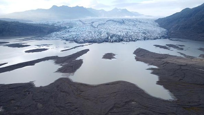 HOFN, HORNAFJORDUR, ICELAND - AUGUST 17: In this aerial view Hoffellsjokull glacier lies behind moraines and an iceberg-filled lagoon the glacier once covered on August 17, 2021 near Hofn, Iceland. Iceland is feeling a strong impact from global warming. Since the 1990s 90% of Icelands glaciers have been retreating and projections for the future show a continued and strong reduction in size of its five ice caps. Flaajokull is one of dozens of glacier tongues that descend from Vatnajokull, Icelands biggest ice cap.  (Photo by Sean Gallup/Getty Images)