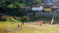 Sejumlah anak terlihat asyik bermain sepakbola di tepian situ yang mengering tersebut.