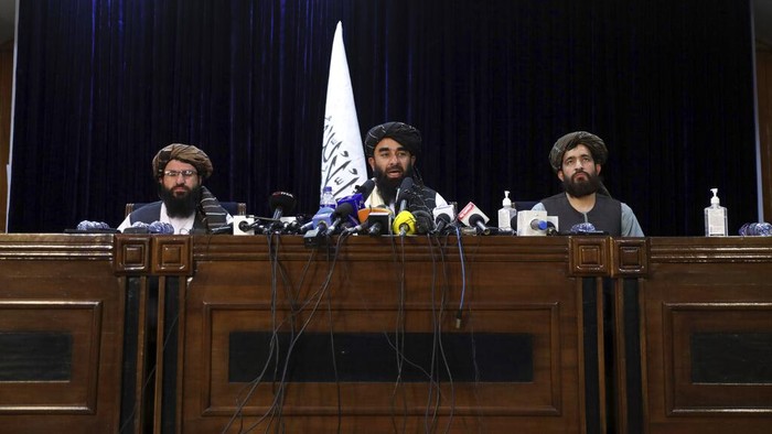 Taliban Janjikan Rezim Berbeda dari Masa Lalu In front of a Taliban flag, Taliban spokesman Zabihullah Mujahid speaks at at his first news conference, in Kabul, Afghanistan, Tuesday, Aug. 17, 2021. For years, Mujahid had been a shadowy figure issuing statements on behalf of the militants. Mujahid vowed Tuesday that the Taliban would respect women's rights, forgive those who resisted them and ensure a secure Afghanistan as part of a publicity blitz aimed at convincing world powers and a fearful population that they have changed. (AP Photo/Rahmat Gul)
