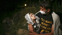 Seorang anak tertidur di pangkuan orang tuanya saat sejumlah pengungsi dari Afghanistan beristirahat di kawasan pedesaan yang berada di Tatvan, Provinsi Bitlis, Turki, Rabu (18/8/2021) malam. AP Photo/Emrah Gurel.