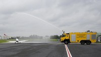 Sebuah truk pemadam kebakaran menyemprotkan pesawat Shark Ultralight milik remaja Belgia-Inggris Zara Rutherford sebelum lepas landas di lapangan terbang Kortrijk-Wevelgem di Wevelgem, Belgia, Rabu (18/8/2021).  