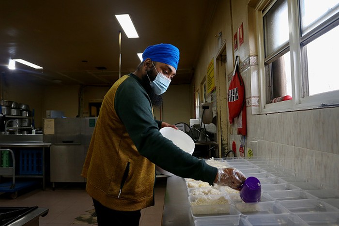 Makanan Gratis Sikh di Sydney SYDNEY, AUSTRALIA - AUGUST 19: Volunteer cooks prepare large volumes of chapati to be packed into meal kits for those in need at the Gurdwara Sahib Glenwood Sikh Temple on August 19, 2021 in Sydney, Australia. The Australian Sikh Association (ASA) serves Sydney's Gurdwara Sahib Glenwood - the largest Sikh congregation in Australia. The Gurdwara Sahib at Glenwood is the hub of religious and community activities all year round with members of the Sikh community visiting the Gurdwara Sahib to pray, meditate and listen to the teachings and hymns from Guru Granth Sahib. During Sydney's COVID-19 lockdown, the ASA has started a daily tiffin service, distributing cooked takeaway food at the main gate providing around 500 meals per day to people in need. For those community members who can't come to temple, ASA volunteers are delivering food, medicines and other supplies to people affected by lockdown restrictions. The Australian Sikh Association has also been active in the community encouraging people to get vaccinated for COVID-19, hosting a vaccination pop up clinic at the Gurdwara Sahib in Glenwood. (Photo by Lisa Maree Williams/Getty Images)