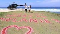 Ada juga sebuah tulisan dan tanda cinta berwarna merah muda yang dituliskan di atas pasir. Foto: Instagram: @melanieputria