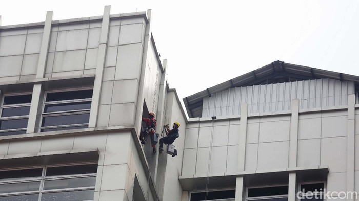 Sejumlah pekerja bergelantungan untuk membersihkan kaca gedung bertingkat di Jakarta. yuk lihat aksinya yang bak Spiderman.