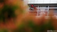Tali pengaman tubuh, helm, kaca mata hitam dan sarung tangan adalah benda yang tak boleh dilupakan. Bekerja sebagai pembersih kaca gedung, di tangannya membawa ember, kain lap, air dan tentu saja cairan pembersih.