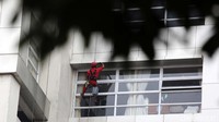 Pekerja membersihkan kaca di sebuah gedung di Jakarta Timur, Kamis (19/8/2021).