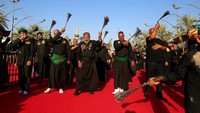 Sejumlah Muslim Syiah memukuli diri mereka dengan rantai sebagai tanda kesedihan di luar tempat suci Imam Hussein selama prosesi Muharram di Karbala, Irak. AP Photo/Anmar Khalil.