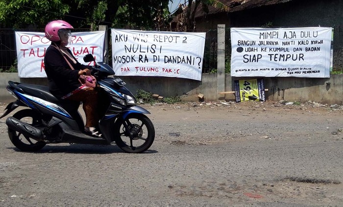 Protes Jalan Rusak, Warga Boyolali Pasang Spanduk Lucu-lucu Jalan Kalioso-Simo, Desa Jeron, Kecamatan Nogosari, Kabupaten Boyolali, Jawa Tengah, rusak parah. Warga pun protes dengan memasang spanduk-spanduk lucu.