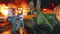Sebuah bus dibakar massa untuk menghambat laju tank Uni Soviet, di Moskow (21/8/1991). Tampak demonstran berhadapan dengan tentara Uni Soviet.