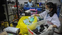 Petugas mengumpulkan limbah masker bekas sekali pakai untuk diolah kembali menjadi barang yang bernilai guna.