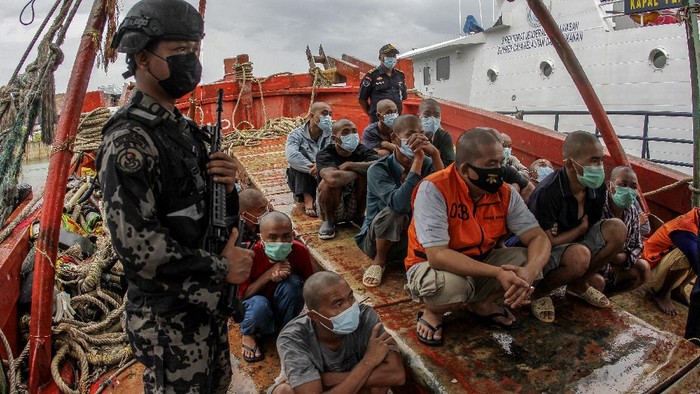 2 Kapal Maling Ikan di Natuna Terciduk KKP Personel Direktorat Jenderal Pengawasan Sumber Daya Kelautan dan Perikanan (PSDKP) mengamankan kapal asing beserta anak buah kapal (ABK) di Pelabuhan Pangkalan PSDKP Batam, Kepulauan Riau, Jumat (20/8/2021). PSDKP berhasil mengamankan kapal asing yang melakukan penangkapan ikan secara ilegal beserta 22 awak kapal berkewarganegaraan Vietnam di Perairan Natuna Utara. ANTARA FOTO/Teguh Prihatna/rwa.
