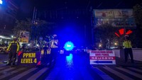 Petugas kepolisian berjaga saat pengalihan arus penerapan jam malam di Jalan Ahmad Yani Km 2, Banjarmasin, Kalimantan Selatan, Kamis (19/8/2021).