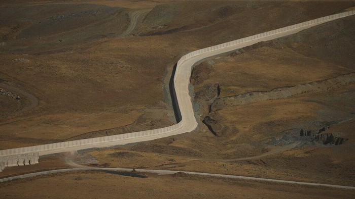 Halau Pengungsi Afghanistan, Turki Bangun Tembok Pembatas A security wall being erected along the frontier between Turkey and Iran, in Van Province, eastern Turkey, Thursday, Aug. 19, 2021. Faced with a potential new wave of migrants from Afghanistan, Turkish President Recep Tayyip Erdogan called on European nations on Thursday to shoulder the responsibility for Afghans fleeing a Taliban onslaught and warned that his country won't become Europe's