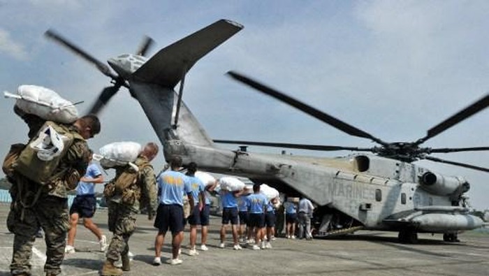 Philippine policemen land US marines load relief goods into a US marine CH-46E helicopter at Cuaayan airport, Isabela province, north of Manila on October 22, 2010, for transport to affected areas devastated by Typhoon Megi.  The death toll in the Philippines from Typhoon Megi, which roared across the country earlier this week, rose to 36 on October 22, the government and Red Cross reported. The typhoon slammed into the northeastern side of the main island of Luzon on October 18, ripping roofs off houses, toppling power lines and nearly destroying some coastal villages.   AFP PHOTO/TED ALJIBE (Photo by TED ALJIBE / AFP)