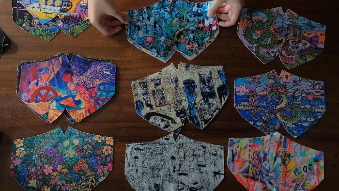 Perajin menunjukkan desain masker bergambar burung Garuda yang sempat viral di media sosial setelah masker dengan gambar yang sama digunakan oleh artis Cinta Laura di Kitasatubali, Badung, Bali, Jumat (20/8/2021). Desain masker kain yang menampilkan gambar dari karya lukisan para seniman lokal Bali, Yogyakarta, Badung, dan Jakarta dengan teknik printing tersebut menembus pasar ekspor di sejumlah negara dengan harga jual Rp45.000 - Rp125.000 per set. ANTARA FOTO/Nyoman Hendra Wibowo/hp.