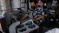 Perajin menyelesaikan pembuatan masker kain dengan teknik printing menggunakan tinta sublim untuk diekspor ke negara Hongkong di Kitasatubali, Badung, Bali, Jumat (20/8/2021). 